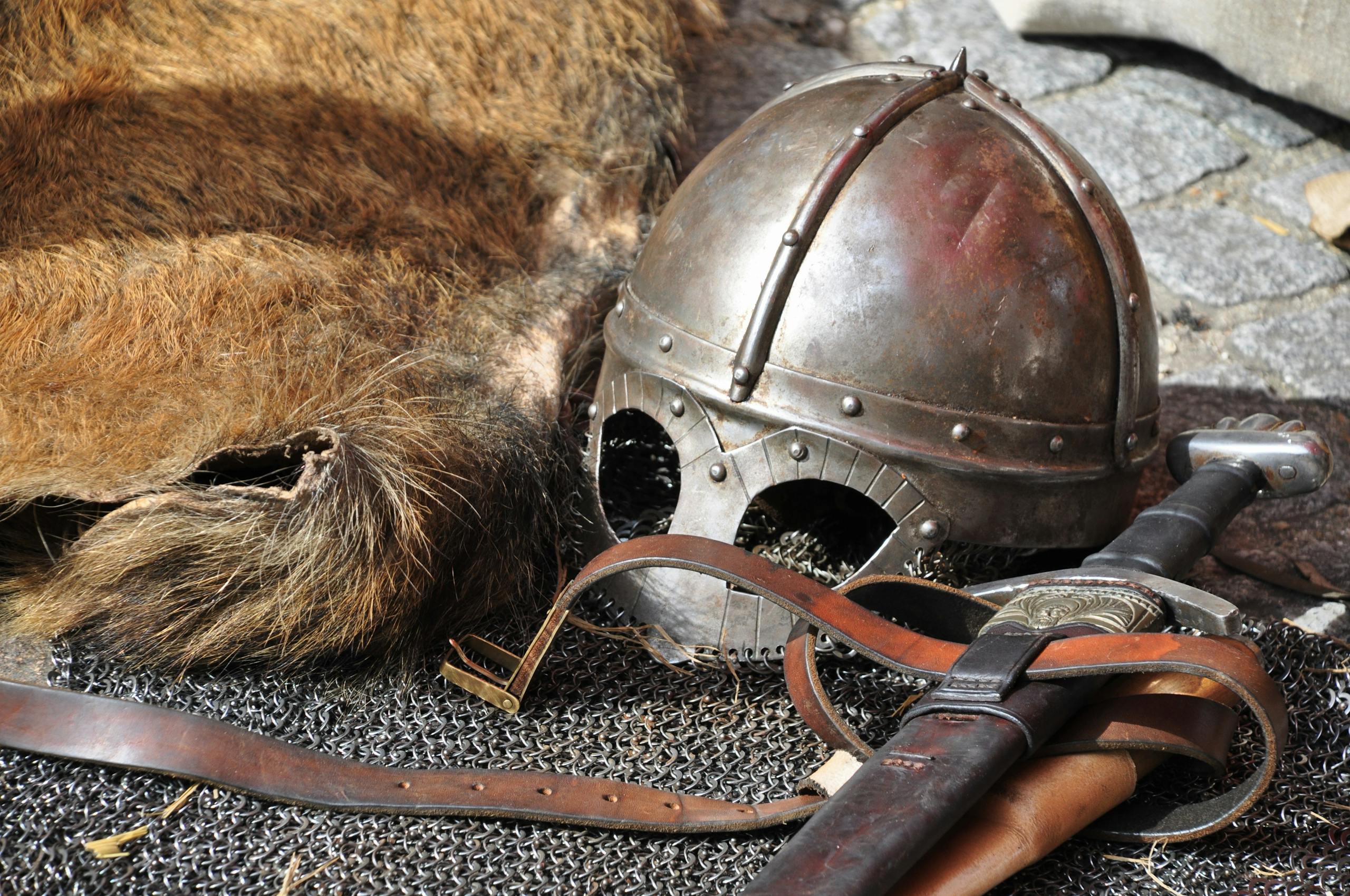 Close-up of medieval armor, helmet, and sword in a classic setting.